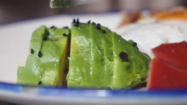 Parlak yeşil avokado dilimleri sağlıklı bir kahvaltıyı tamamlamaya hazır..