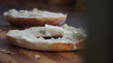 Kahvaltı için simit dilimleyip krem peynir sürüyorum..