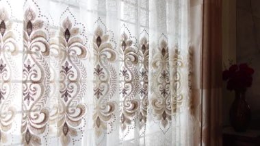 Dantel perdelerin arasından ışık akıyor, odayı ısıtıyor..