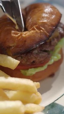 Lezzetli hamburgerin üstüne taze malzemeler ve kızarmış patates..