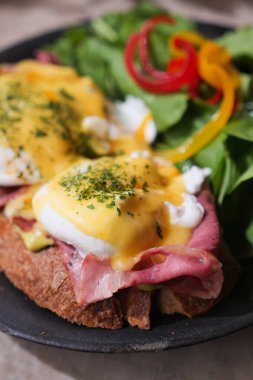 Kahvaltıda haşlanmış yumurta, jambon ve taze yeşillik servis edilen lezzetli yemekler..
