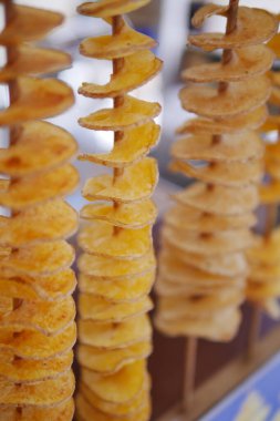 Spiral kesim patatesler yerel bir markette tahta çubuklarda sergilenir..