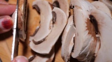 Bir şef ustalıkla taze mantarları dilimler, yemeğe hazırlanır..