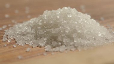 Beyaz şeker kristallerinin döküldüğü yakın plan.
