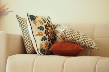 Çeşitli desenlerde dekoratif yastıklar ve renkler yumuşak bir kanepede dinleniyor..