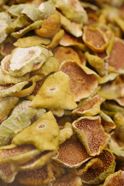 Bir market tezgahında üst üste yığılmış renkli incir dizisi.