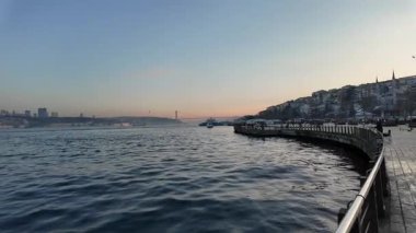 İstanbul 'da güneş suyun üzerinde batarken gökyüzü yavaşça kararıyor.