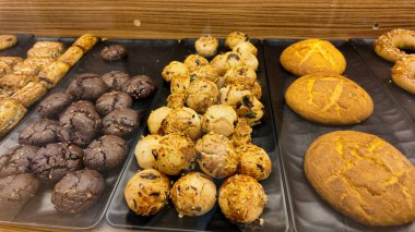 Gündüz vakti bir pastane vitrininde sunulan çeşitli kurabiyeler.