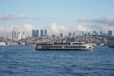 İstanbul ufuk çizgisini gören bir yolcu feribotu suda yüzüyor.
