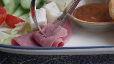 Pişmiş et dilimlemek ve yemek için taze sebze hazırlamak..