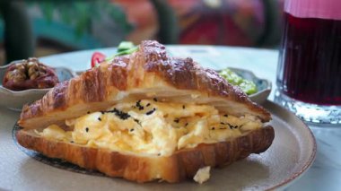 Omlet ve taze kenarlarla dolu enfes bir kruvasanın tadını çıkarın..