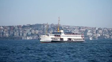 İstanbul şehrinin manzarasını gösteren feribot su üzerinde sorunsuzca hareket ediyor.