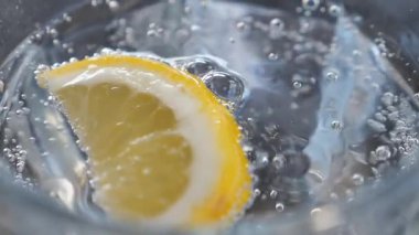 Limon dilimi ferahlatıcı, köpüklü suda yüzer, parlak bir ekran yaratır..