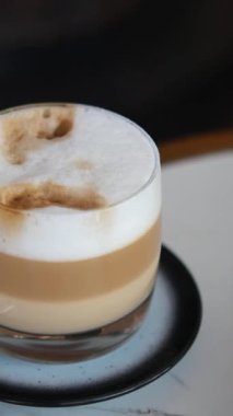 Süt ve köpüklü kremalı bir kahve içiyorum..