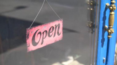 Bir karşılama tabelası dükkanın açık olduğunu gösteriyor..