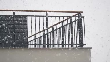Soğuk bir kış gününde balkon korkuluklarına şiddetli kar yağar..