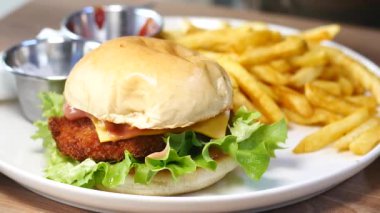 Kızarmış patates ve marul ve peynirli cazip bir tavuklu sandviç..