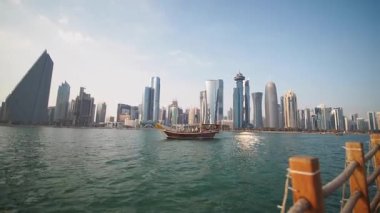 Turistler Katar 'daki yüksek binaların yakınında manzaralı bir tekne turunun keyfini çıkarıyorlar..