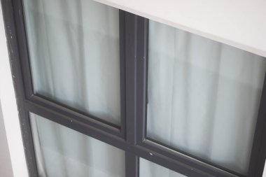 Modern bir ortamda şık bir pencere hafif kumaş perdeleri sergiler.