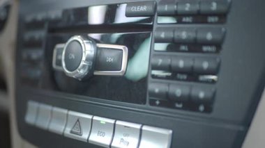 Kullanıcı bir araba torpido gözündeki ses kontrol paneliyle etkileşim kurar.