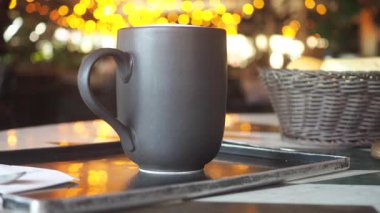 Bir insan büyüleyici bir kafede dumanı tüten bir fincan kahveyle rahatlar..