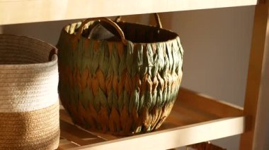 El dokuması sepetler yumuşak ışıkta ahşap bir rafta sergilenir..