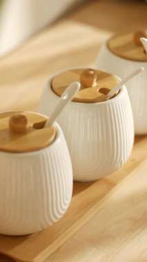 Tahta bir yüzeye yerleştirilmiş ahşap kapaklı eşsiz seramik kavanozlar..