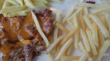 Tatmin edici bir yemek için kızarmış tavuk, patates kızartması ve makarna..