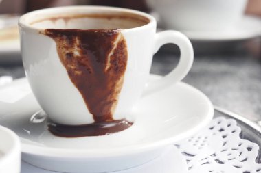Moda bir kafede kahve fincanından erimiş çikolata damlaları..