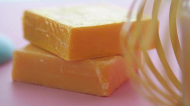 Pembe arka planda bir yığın turuncu sabun .