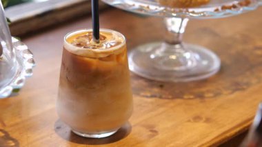 Sıcak bir kafede servis edilen lezzetli buzlu kahvenin tadını çıkar..