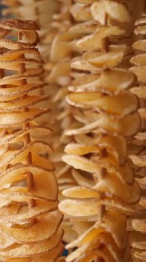 Spiral kesim patatesler, hareketli bir pazarda altın bir gevrekte kızartılıyor..