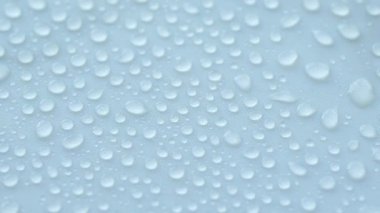 Su damlacıklarının yakın çekim görüntüsü bir yüzey üzerinde benzersiz desenler oluşturuyor.