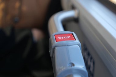 Gün içinde bir otobüsün içindeki kırmızı dur düğmesine yakın çekim.