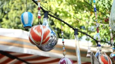Parlak renkli süsler canlı bir pazar ortamının üzerinde sallanıyor..
