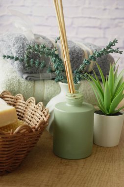 Havlular, difüzör ve bitkiler gibi rahatlatıcı spa öğeleri.