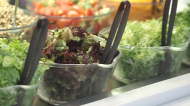 Salata sebzeleri ve sebzeler bir markette açık kaplarda sergilenir..