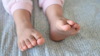 Yumuşak bir yüzeyde küçük ayaklar dinlenirken sessiz zaman geçirir..