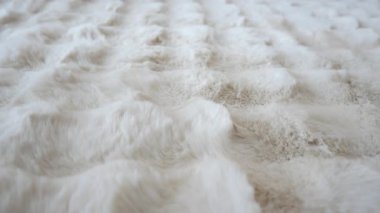 Video kapalı bir ortamda yumuşak, dokulu bir kumaş sergiliyor..