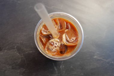 Buz küpleri ve pipetle ferahlatıcı bir buzlu kahve..