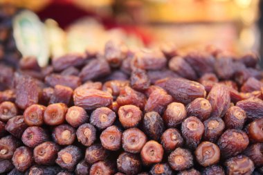 Kalabalık bir pazarda taze kurumuş tarihler üst üste yığılmış..