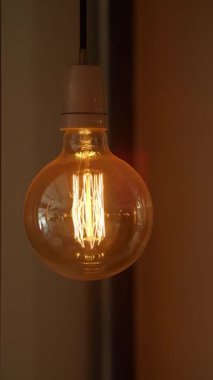 Ilık bir ampul loş bir odada parlıyor, hoş bir karşılama havası yaratıyor..