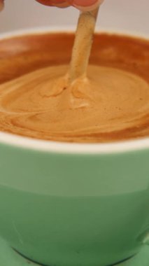 Tatlandırıcı bir ortamda köpüklü kahveyi ustalıkla karıştırmak.