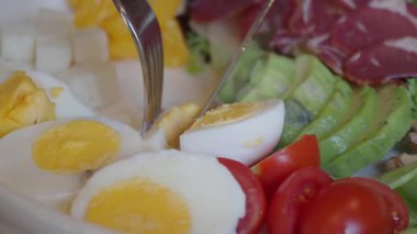 Canlı bir salatanın içinde taze sebzeler ve yumurtalar var..