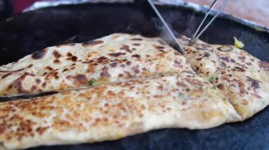 Pişirme ustalığı ile sıcak bir yüzeyde büyük bir peluş ekmek hazırlar..