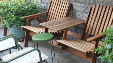 Tahta sandalyeler ve masa bitkiler arasında rahatlamaya davetiye çıkarır..