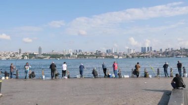 Birkaç balıkçı halatlarını hareketli bir limanda suya attılar..