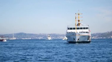 Feribot, Istanbuls limanında yakınlarda teknelerle birlikte suda yolculuk ediyor..