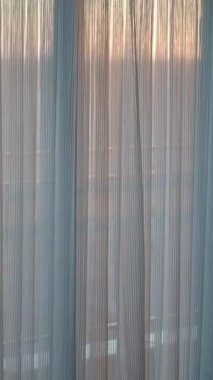 Sabah ışığı perdelerin arkasında sakin bir atmosfer yaratır..