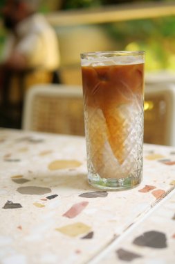 Bir kafede sıcak bir masada ferahlatıcı bir buzlu içecek bekliyor..